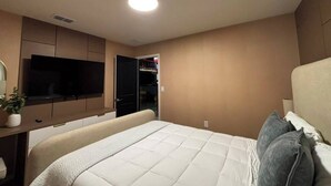 Een hotelkamer met een bed, een televisie, een bureau en een kledingkast.