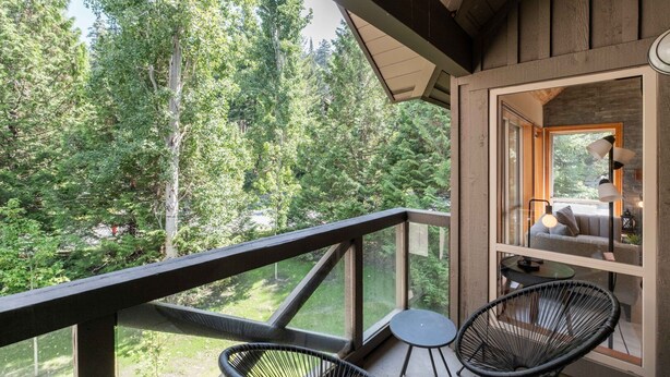 A wooden deck with a view of a forest, a sofa, and two chairs. - Excellent Ski-in/out | Complex hot tub | BBQ (Whistler)