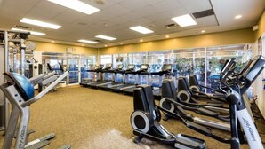 Een fitnessruimte met loopbanden, elliptische trainers en krachtapparaten.