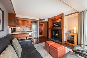Ein modernes Wohnzimmer mit Kamin, eine Küche mit Holzschränken und ein Essbereich.