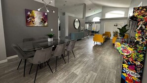 Una cocina moderna con comedor, un ventanal grande y un colorido expositor de juguetes.