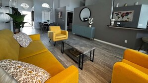 Una sala de estar moderna con sofá, sillón y mesa de centro.