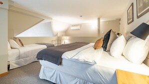 Un dormitorio con cama, sofá, lámpara y luz de techo.