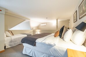 A bedroom with a bed, a sofa, a lamp, and a ceiling light. - Penthouse, Mountain Views, Ski-In/Out, Pool, Hot Tub, Gym (Whistler)