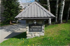 A stone sign with a metal roof labeled "The Marquise 4809 Spearhead Drive." - Penthouse, Mountain Views, Ski-In/Out, Pool, Hot Tub, Gym (Whistler)