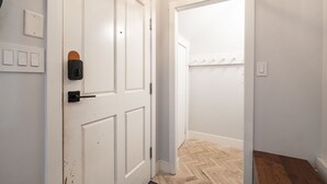 A hallway with white doors, a light switch, and a doorbell. - Great location | Complex hot tub | BBQ | Pets (Whistler)