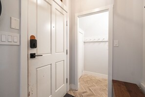 A hallway with white doors, a light switch, and a doorbell. - Great location | Complex hot tub | BBQ | Pets (Whistler)