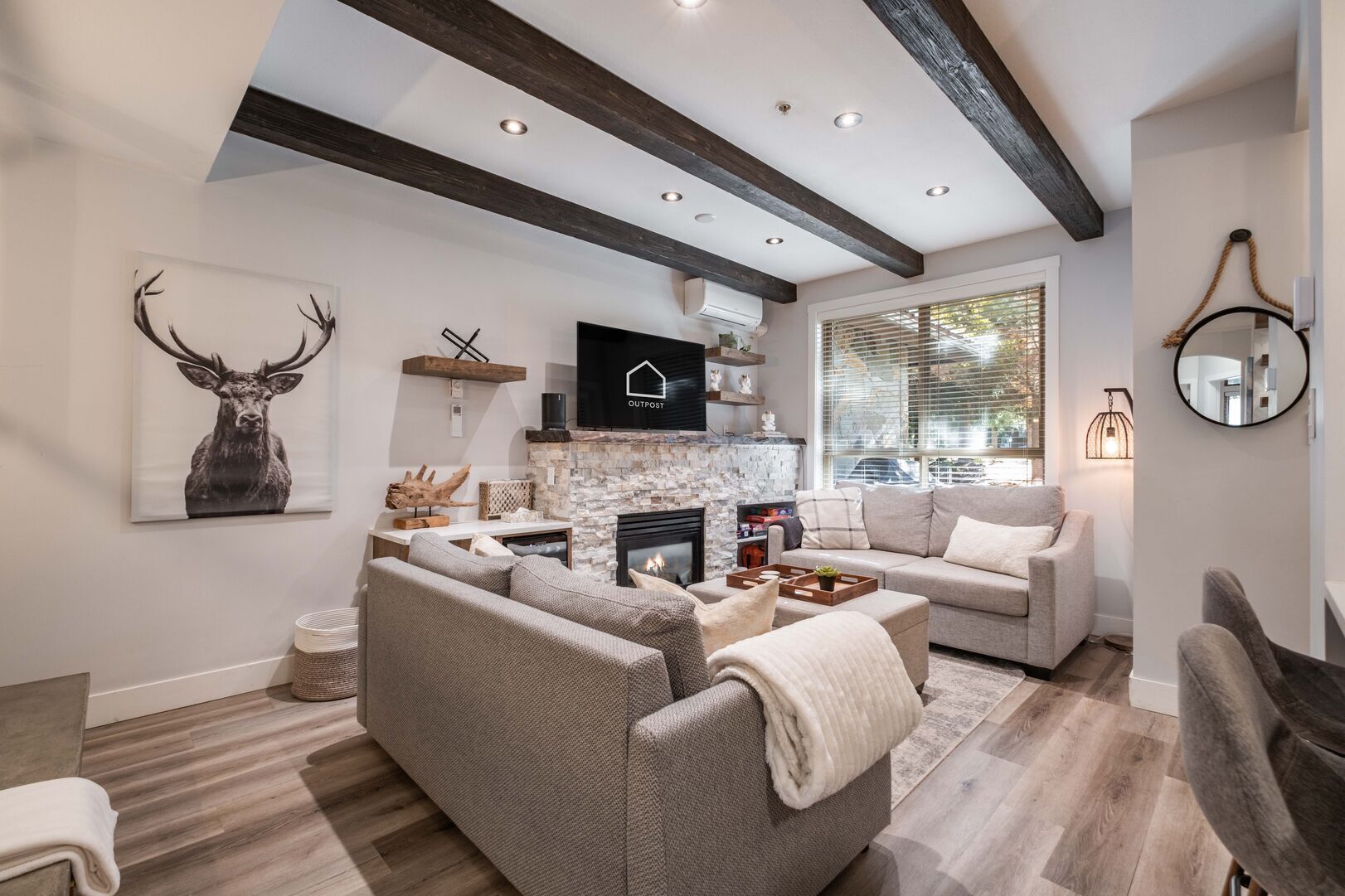 Ein modernes Wohnzimmer mit Kamin, einer großen Couch und einem Fernseher.