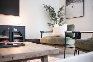 Un salon moderne avec un canapé, une table basse et une bibliothèque.