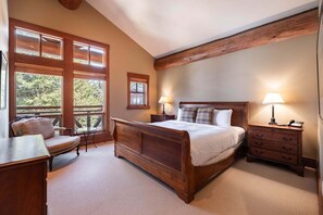 A bedroom with a wooden bed, two bedside tables with lamps, a chair, and a desk. - NEW Townhome | Private hot tub | Smart TV (Whistler)