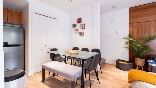 A compact living space with a kitchenette, dining area, and a small seating area. - NEW Townhome | Private hot tub | Complex pool (Whistler)