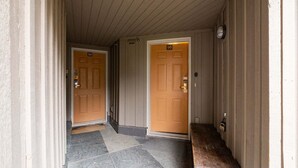 A hallway with two wooden doors, each marked with a number. - NEW Townhome | Private hot tub | Complex pool (Whistler)
