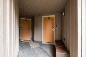 A hallway with two wooden doors, each marked with a number. - NEW Townhome | Private hot tub | Complex pool (Whistler)