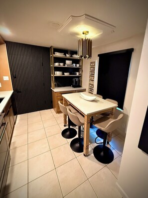 A compact kitchen with a dining table, chairs, and a built-in shelf unit. - Central R&R Cape Cod (Casper)