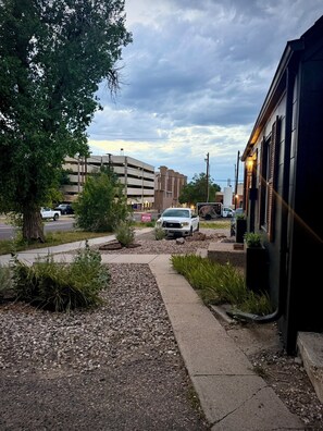 A parking area with a white pickup truck, a building with a sign, and a tree. - Central R&R Cape Cod (Casper)