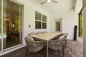 A dining area with a table and chairs, a ceiling fan, and a glass door leading to an outdoor space. - Resort Amenities Included! 7 BD/ 6 BA/ Storey Lake 4585 TB (Kissimmee)