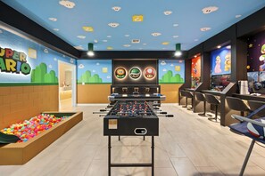 A room with a foosball table, colorful ball pit, and gaming consoles. - Resort Amenities Included! 7 BD/ 6 BA/ Storey Lake 4585 TB (Kissimmee)