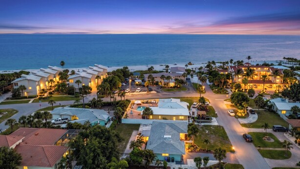 A coastal residential area with multiple houses, a swimming pool, and a view of the ocean. - Beach House Oasis - Steps from Ocean Access (Venice)