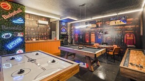 A sports-themed bar area with foosball tables, a pool table, and sports jerseys displayed on the wall. - 6 BD/ 5 BA/ Solara Resort (9038 SR) (Kissimmee)
