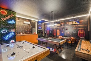Eine Sportbar mit Fußballtisch, Billardtisch und Trikots an der Wand.