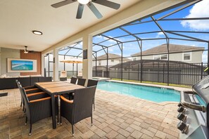 A covered patio with a pool, outdoor furniture, and a grill area. - 6 BD/ 5 BA/ Solara Resort (9038 SR) (Kissimmee)