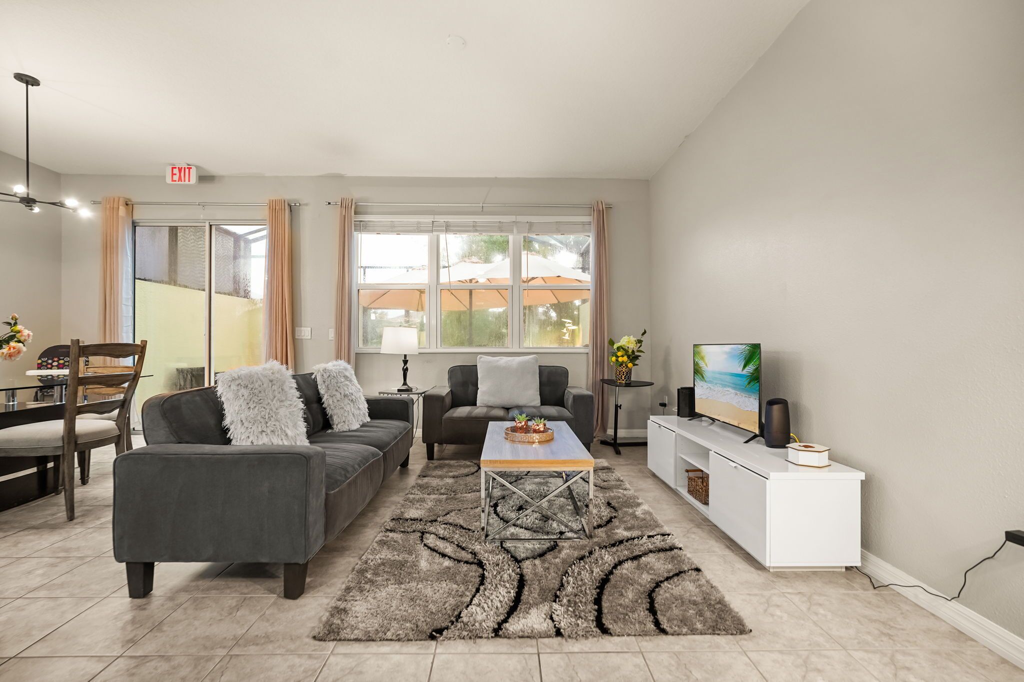 A modern living room with a sofa, coffee table, and a TV on a stand.