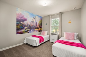 Une chambre avec deux lits, une grande fresque murale, une fenêtre avec des rideaux et une petite table avec des lampes.