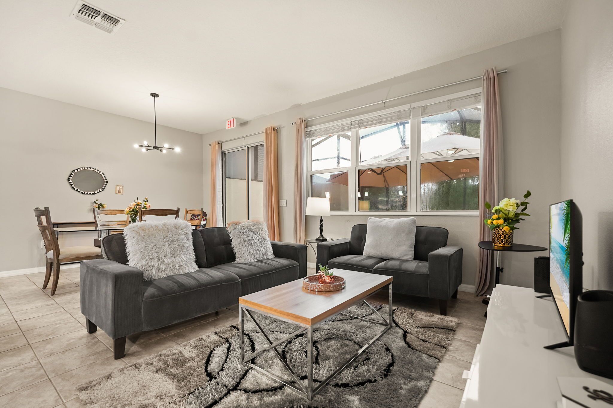 Un salón moderno con dos sofás, una mesa de centro y un comedor con una silla y una mesa.
