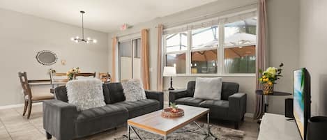 A modern living room with two sofas, a coffee table, and a dining area with a chair and table.