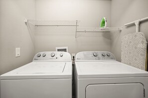 A laundry room with two front-loading Whirlpool washers, a green iron, and a patterned towel rack. - 4 BD/ 3.5 BA/ Compass Bay (3183 TC) (Kissimmee)