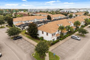 A residential area with multiple two-story houses, a parking lot, and a clear sky. - 5 BD/ 4 BA/ Storey Lake (4823 BR) (Kissimmee)