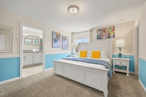 A bedroom with a bed, a nightstand, a lamp, and artwork on the walls. - 5 BD/ 4 BA/ Storey Lake (4823 BR) (Kissimmee)