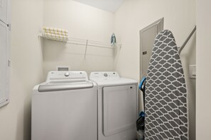 A laundry area with two washing machines, a drying rack, and a shower curtain. - 5 BD/ 4 BA/ Storey Lake (4823 BR) (Kissimmee)
