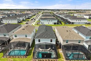 A residential area with multiple houses, each featuring a swimming pool with a glass enclosure. - 7 BD / 5.5 BA / Windsor Cay 16115 CC (Clermont)