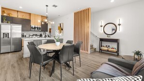 Eine moderne Küche mit Essbereich, einer Couch und einer Treppe.