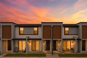 A modern multi-story residential building with large windows and sliding doors. - 3 BD/ 3 BA/ The Hub at Westside Reserve (3263 SW) (Kissimmee)
