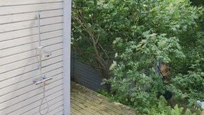 En træterrasse med en metalhane ud til siden af en bygning.
