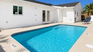 A swimming pool with a white building, a door, and a window. - 🏖️3BD/2BA Walk to Beach & Downtown / Pool / 349NO (Cocoa Beach)
