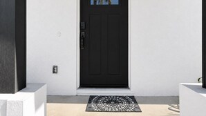 A black door with a window above it, a doormat, and a white wall. - 🏖️3BD/2BA Walk to Beach & Downtown / Pool / 349NO (Cocoa Beach)