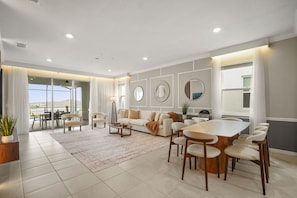 A spacious living room with a large dining table, sofas, and a view of the outdoors. - Luxury 6BD/4.5BA Windsor Island (3763 La) (Davenport)