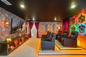 Ein gemütliches Wohnzimmer mit Backsteinwand, Ledersofas, Kamin und Flachbildfernseher.