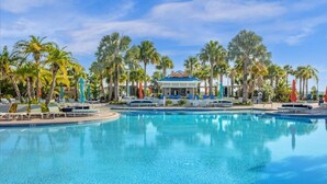 Ein großer Pool mit Liegestühlen und Palmen.
