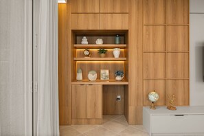 Ein Holzkabinett mit Regalen, das dekorative Gegenstände und einen Globus oben beherbergt.