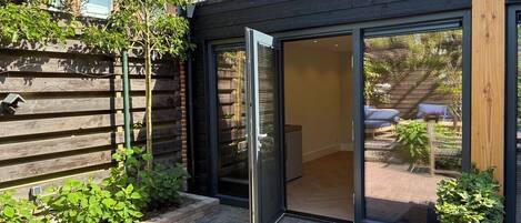 Une maison moderne dotée d’une porte-fenêtre coulissante qui donne sur un patio.