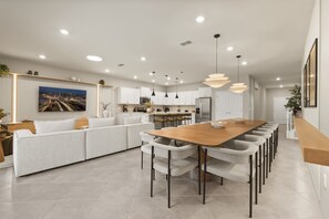 A modern kitchen with white cabinetry, a large island, and pendant lighting. - Immersive Themed Bedrooms 10 BD/ 8 BA/ Windsor Cay - 16030CC (Clermont)