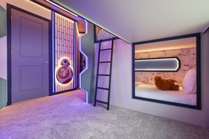 A room with a bunk bed, a ladder, a door with a lighted panel, and a wall with a geometric pattern. - Immersive Themed Bedrooms 10 BD/ 8 BA/ Windsor Cay - 16030CC (Clermont)