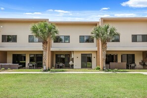 A modern two-story building with a flat roof, large windows, and a well-maintained lawn. - 4 BD/ 4.5 BA/ Magic Village Views (7478 BD) (Kissimmee)
