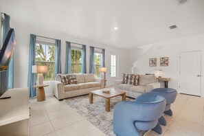 A modern living room with two sofas, a coffee table, and a TV. - 3 BD/ 2.5 BA/ The Enclaves at Festival (1773 SD) (Davenport)