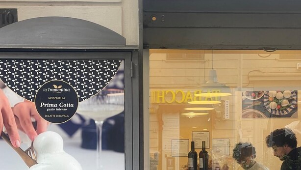 En butik med ett skyltfönster i glas där en reklam för matvaror visas.