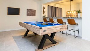 Une table de billard avec un bar en arrière-plan.